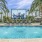 a pool with palm trees and a large painting on the wall