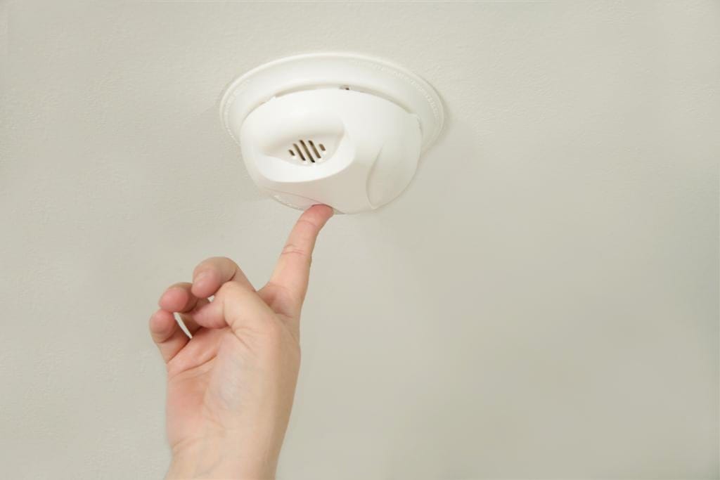 a person installing a smoke detector