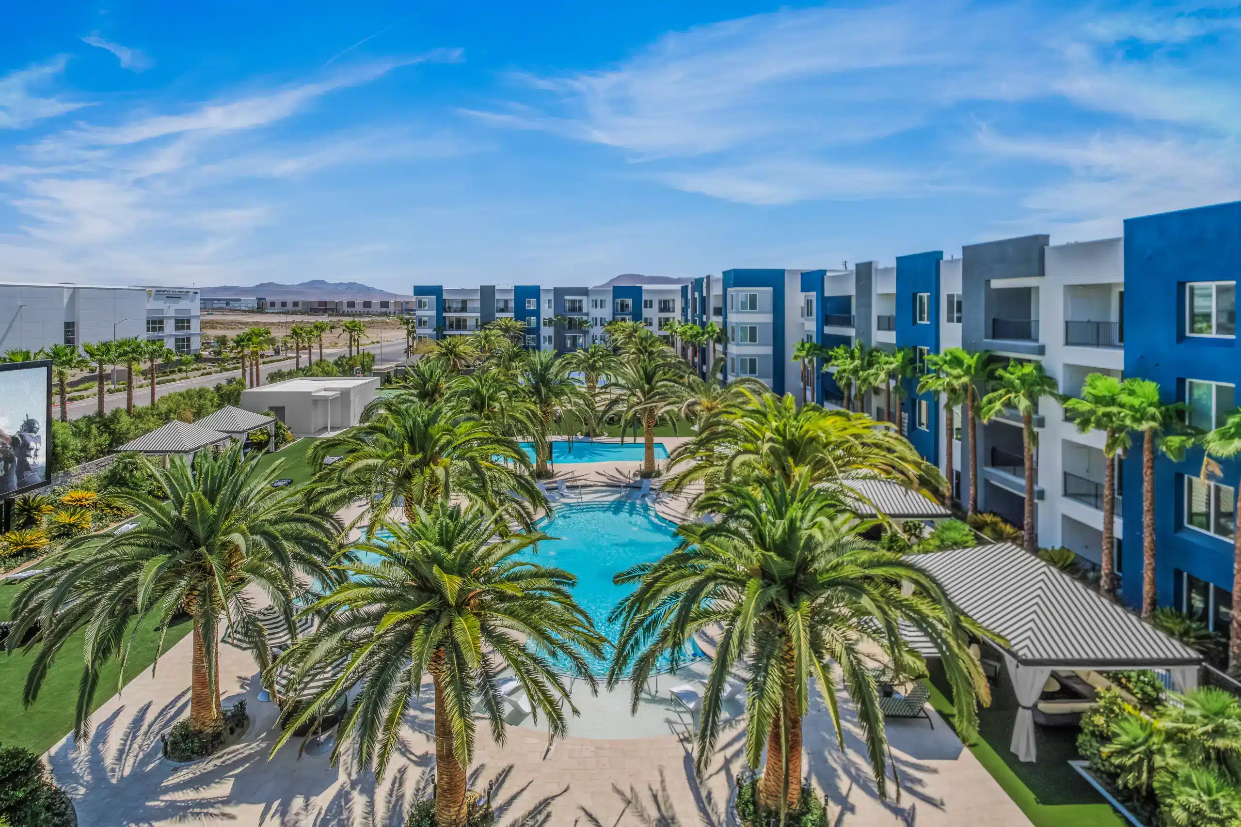 view of palm trees and a pool from a balcony