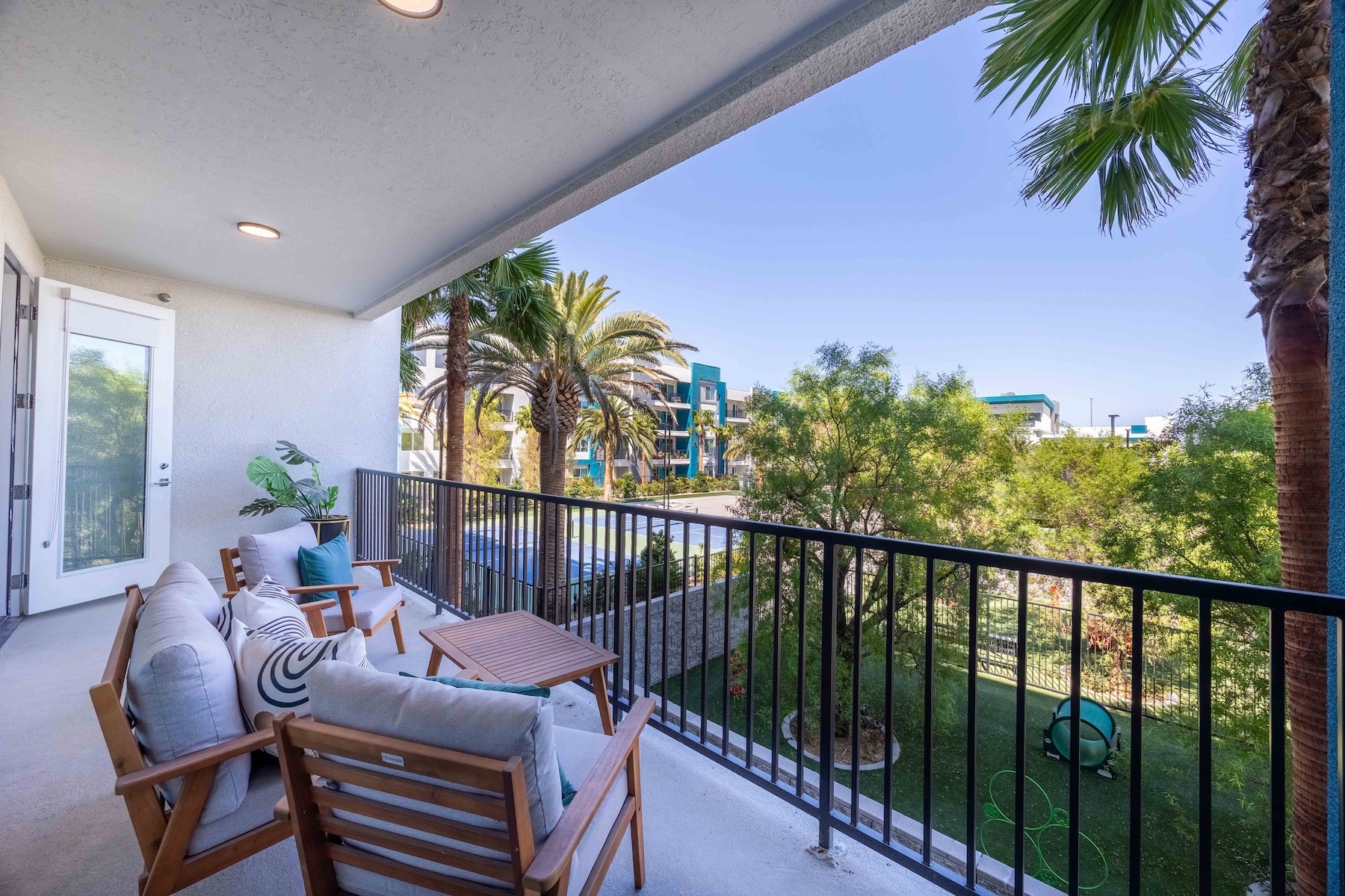 person sitting in a chair on their balcony overlooking palm trees