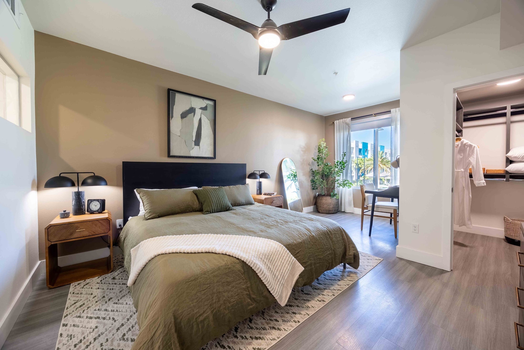 bedroom with ceiling fan and large windows